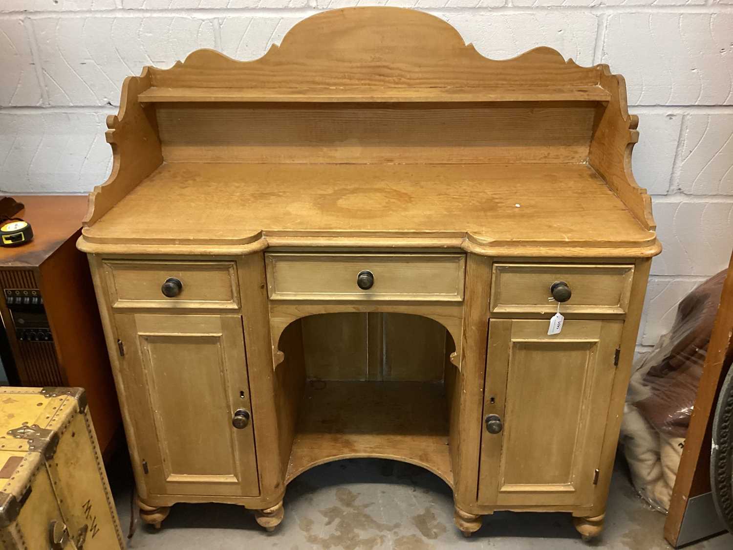 Victorian pine sideboard with raised ledge/shelf back, three drawers and central recess below flanke