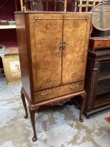 Queen Anne-style walnut cocktail cabinet with mirrored interior , two doors and drawer below on carv