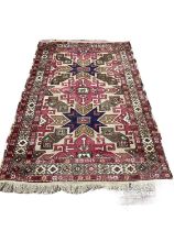 Eastern rug with geometric decoration on red, blue and green ground, 222cm x 140cm
