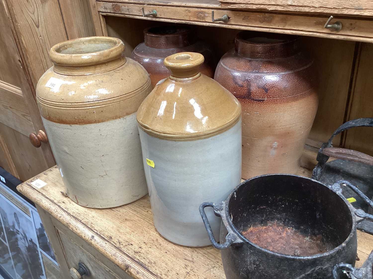 Group of stoneware items and cast iron cooking pots.