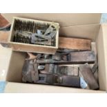 Box of vintage woodworking tools including planes and a boxed scientific instrument