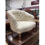 Victorian tub chair with buttoned cream upholstery on turned front legs and castors