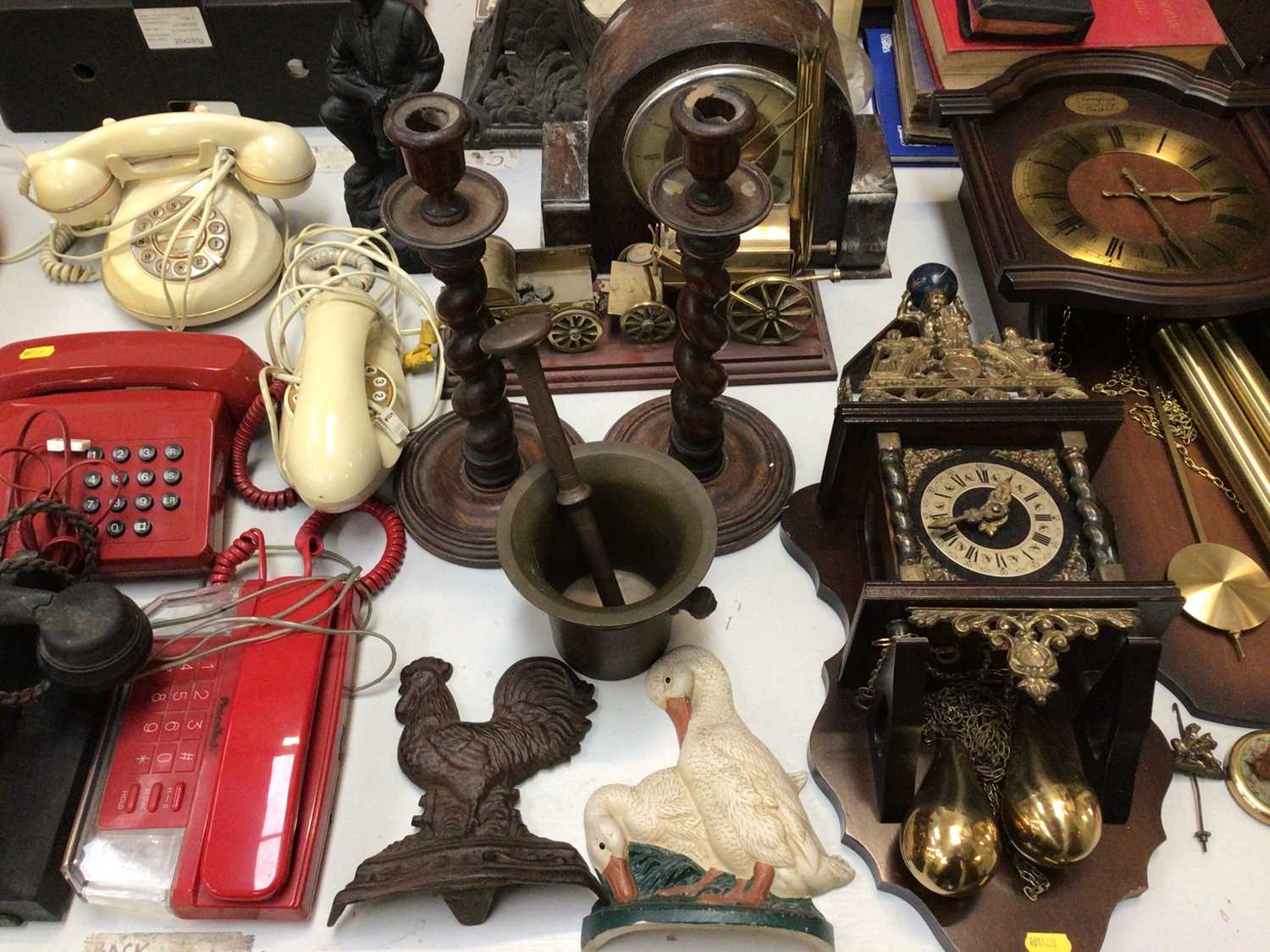 Group of vintage telephones, three wooden clocks, pair of barley twist candlesticks, box of brasswar
