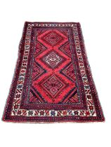Eastern rug with three central medallions on red, blue and cream ground, 186cm x 99cm