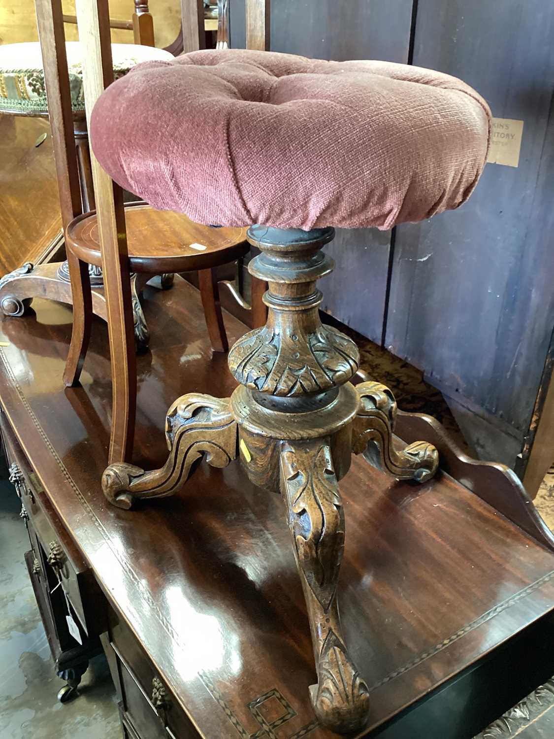 Victorian piano stool with revolving adjustable pink upholstered seat on three carved legs