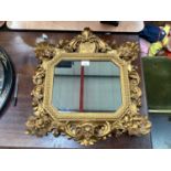 Antique carved giltwood decorative hanging mirror with central crest containing initials.