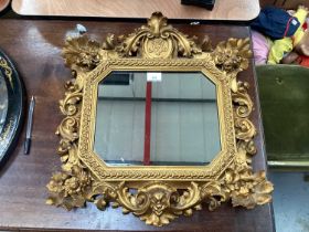 Antique carved giltwood decorative hanging mirror with central crest containing initials.