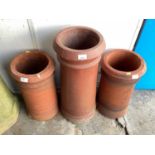 Three terracotta chimney pots, 64cm high and the other two are 47cm high