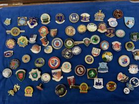 Collection of enamel bowls club badges, including Essex, in a glazed cabinet. Approximately 70.