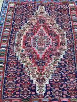 Eastern rug with geometric decoration on red and blue ground, 152cm x 120cm