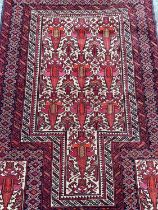 Baluch rug with geometric decoration on red ground, 144cm x 93cm