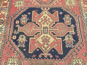 Eastern rug with geometric decoration on red and blue ground, 230cm x 148cm