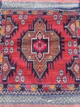 Eastern rug with central medallion on red and blue ground, 133cm x 83cm