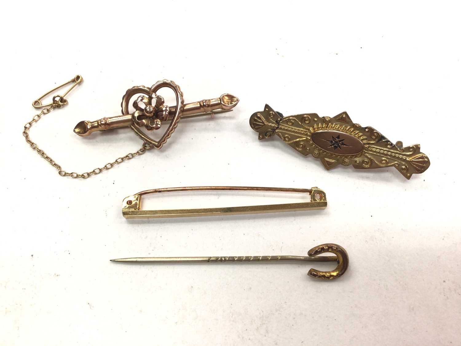 Two 9ct gold bar brooches, 9ct gold tie pin and a gold horseshoe stick pin