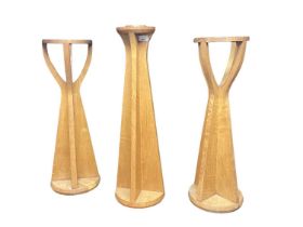 Honey oak stand, with dished top and pair of similar candle stands