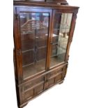Old Charm oak display cabinet with glass shelves enclosed by two leaded glazed doors, and two carved
