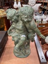 Hollow cast metal garden ornament in the form of two children playing.