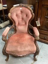 Victorian heavily carved mahogany open arm chair with velvet upholstery