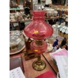 Cranberry glass and brass oil lamp with shade