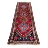 Persian runner with five central medallions on red, blue and cream ground