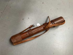 Military scope in brown leather case.