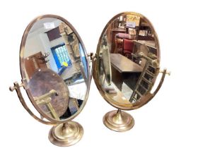 Pair of brass framed oval swing mirrors