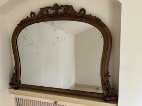 Victorian gilt framed overmantel mirror of shaped form with carved scroll cresting