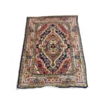 Eastern rug with geometric decoration on red, orange, blue and green ground, 97cm x 73cm