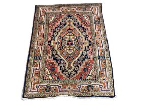 Eastern rug with geometric decoration on red, orange, blue and green ground, 97cm x 73cm