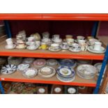 Two shelves of assorted teaware and plates together with various collectors plates