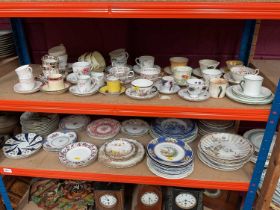 Two shelves of assorted teaware and plates together with various collectors plates