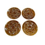 Set of four French Niderviller pottery treacle glazed oyster plates, each 25cm in diameter (4).