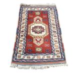 Eastern rug with central medallion on red, blue and cream ground, 133cm x 87cm
