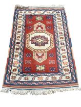 Eastern rug with central medallion on red, blue and cream ground, 133cm x 87cm