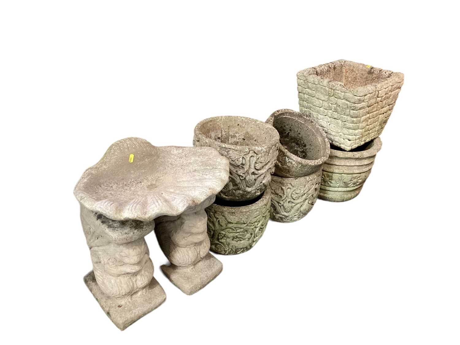 Six various concrete garden planters, together with a bird bath and two bench ends