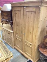 Antique pine wardrobe enclosed by pair of panelled doors.