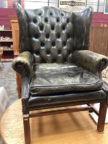 Georgian-style buttoned green leather wing chair on chamfered legs