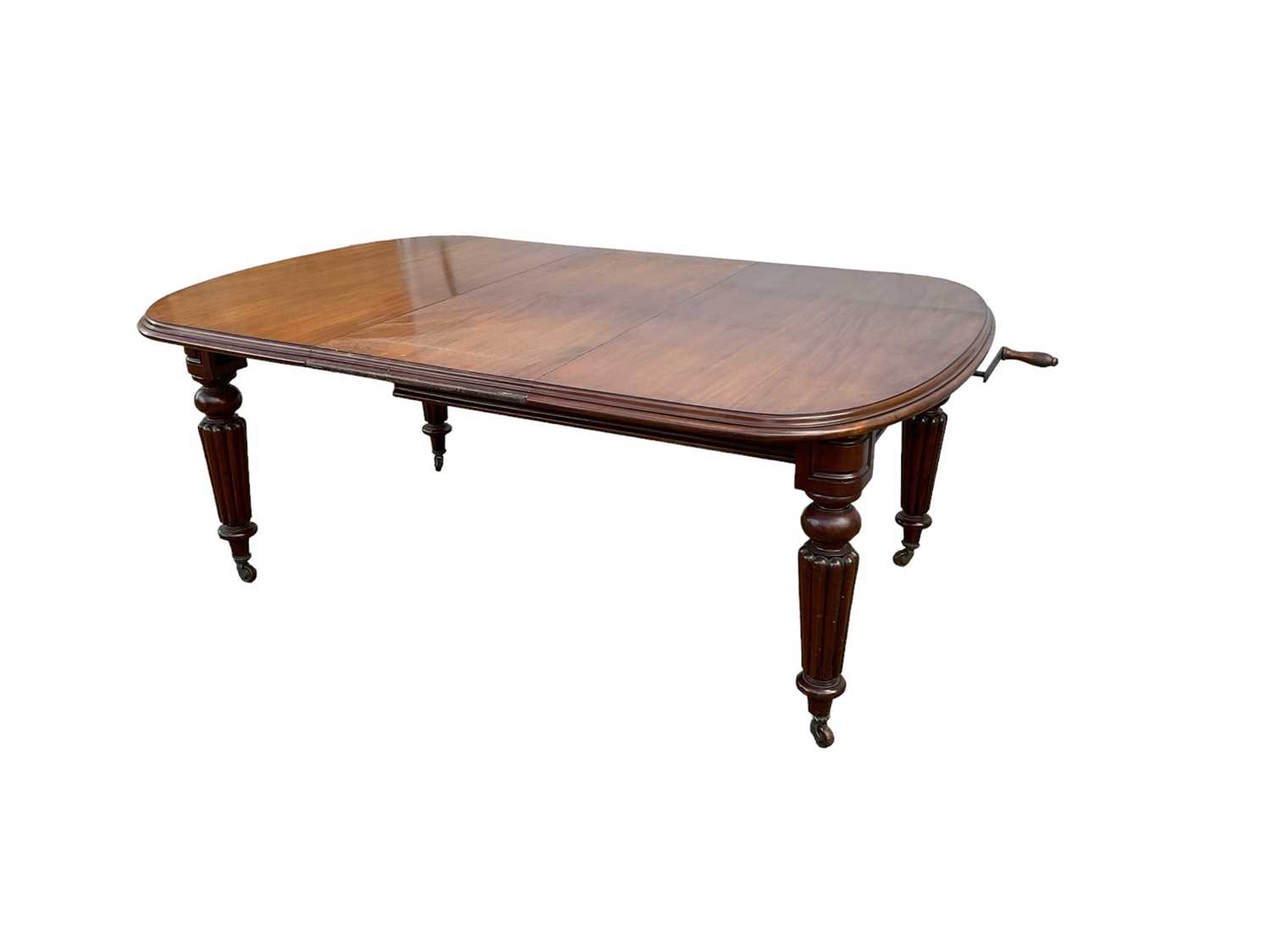 Victorian mahogany extending dining table with extra leaf on turned and reeded legs with winding han