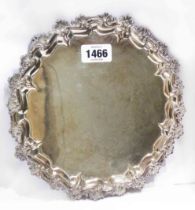 A 23.5cm diameter late Victorian silver salver by Goldsmiths Alliance with ornate cast rim, set on