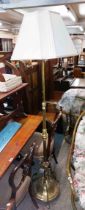 A Victorian style brass telescopic standard lamp, set on a circular base with decorative triple