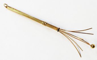 A 375 (9ct.) gold telescopic swizzle stick with engine turned decoration and suspender loop