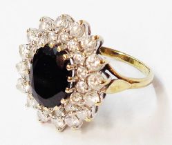 A 375 (9ct.) gold dress ring, set with central oval black onyx stone within a CZ encrusted