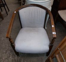 A vintage stained beech framed bow elbow chair with studded calico upholstery, set on turned front