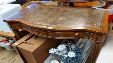 A 93cm reproduction mahogany break bow front writing table with leather inset top and two frieze