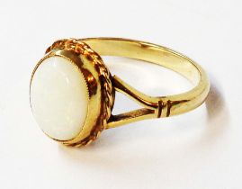 A marked 9ct. yellow metal ring, set with milky opal oval cabochon - size P 1/2