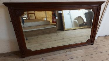 A 1.15m Edwardian stained walnut overmantel mirror with carved decoration and shaped bevelled oblong