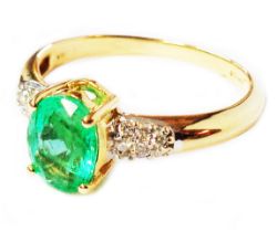 A 750 (18ct.) gold ring, set with central oval emerald with tiny diamonds to shoulders - size Q -