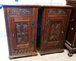 A pair of 53.5cm antique style carved oak pot cupboards, each with panelled sides and enclosed by