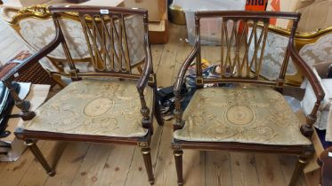 A pair of French antique style mahogany elbow chairs with pierced splat backs, gilt highlighting and
