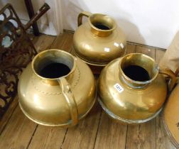 A set of three graduated large brass water jugs